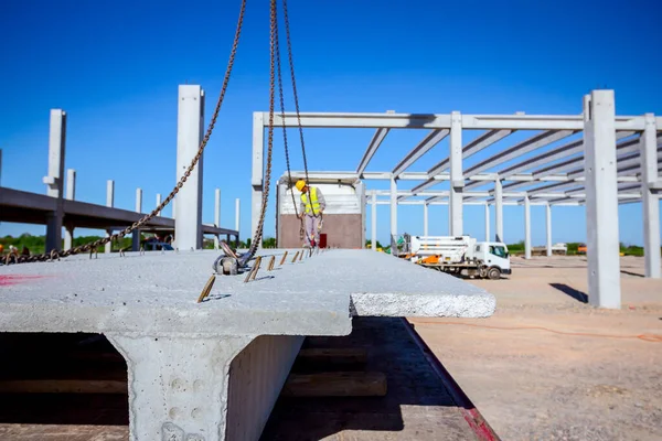 A munkás daru kampókat erősít a betongerendára a teherautó ösvényén. — Stock Fotó