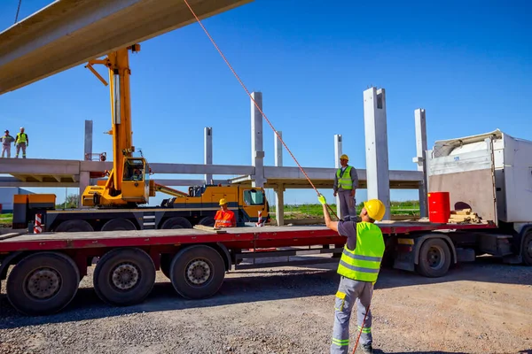 Trabajador está ayudando a la grúa desde el suelo, mantener el equilibrio y directo — Foto de Stock