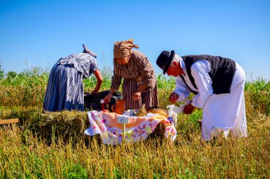 Muzlja, Vojvodina, Serbia, - July 06, 2019; Elderly man and women are preparing breakfast in retro style, like old times