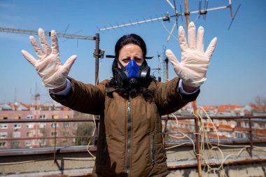 Medya baskısını durdurun. Endüstriyel maske takan kadının yüzünde kağıt filtre var. Elleri, hareketi, sosyal mesafesi, uzak durması, COVID-19 virüsüne karşı korunması, Corona.