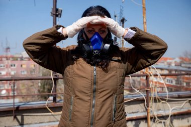 Kadın, COVID-19, Corona 'dan korunmak için kağıt filtresi ve eldiven takmış endüstriyel maske takıyor.. 