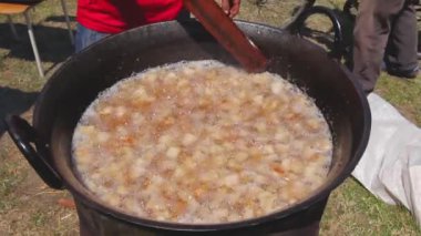 Geleneksel bir şekilde taze domuz yağlarını eritmek, domuz pastırması, derin demir kazanda çatırdamak. Yığınla uzun tahta kaşığı karıştır