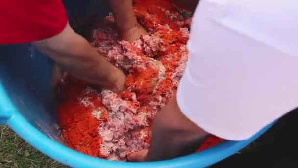 男人们正在一起工作 把切碎的肉混合在一个很深的塑料碗里 强迫人们在室外加工香肠 — 图库视频影像