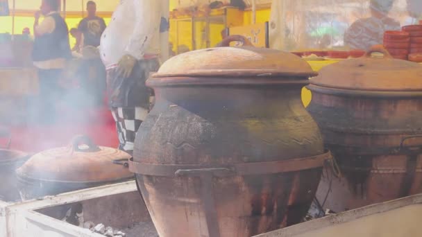 大量的食物是用一个巨大的陶瓷锅 锅子在火上烤着 — 图库视频影像