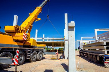 Vinçler-Mobil vinç zinciri üzerinde asılı büyük bir beton kiriş ile çalışma.