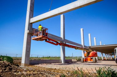 Vinçler-Mobil vinç işletim ve derleme beton kiriş yüksek yerde çalışıyor. Yükseklik işçi iskelet bina truss çiziyor.