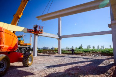 Vinçler-Mobil vinç işletim ve derleme beton kiriş yüksek yerde çalışıyor. Yükseklik işçi iskelet bina truss çiziyor.