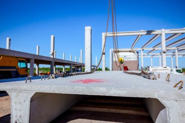 İşçi Vinç kanca kamyon römork gelen boşaltma beton kiriş için hazırlanıyor.