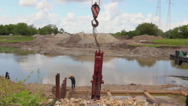 塞尔维亚伏伊伏丁那的Zrenjanin 2019年5月21日 气动打桩机将金属板冲入河岸 以制造挡土墙 直到悬挂在建筑工地的起重机钩上 — 图库视频影像