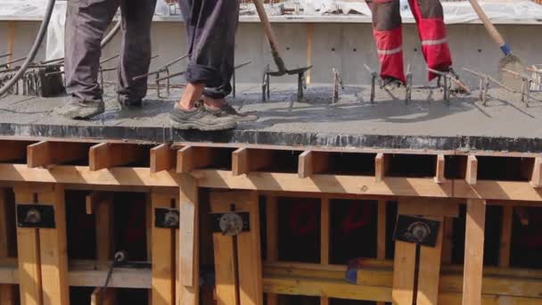 建筑工人们正在使用电动工具 压实机和铲子将木模中的新鲜混凝土与钢筋对齐 — 图库视频影像