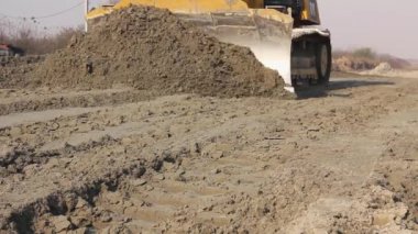 İnşaat alanındaki kumu iterken buldozerin şasisini kapatın..