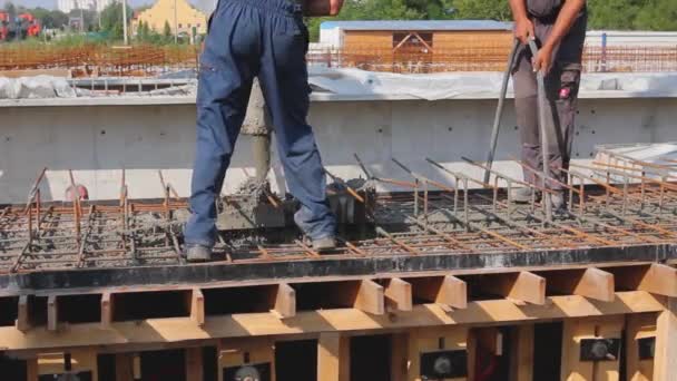 建筑工人正在浇注混凝土 他们正在使用电动工具 压实器 在木制模具结构内浇注混凝土 — 图库视频影像