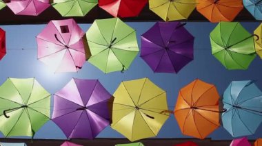 Renkli şemsiyeler asılıyor gökyüzünü şehir caddesine boyuyor, başımızı süpürüyor..