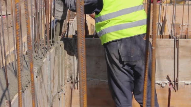 建設現場の労働者はミキサー車からポンプホースを管理する長い金型にコンクリートを注いでいます — ストック動画