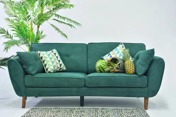 Green sofa under white backround with pillows
