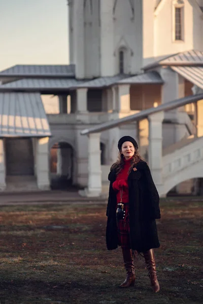 Genç ve güzel bir kız sonbahar yürüyüşü şehir mimarisinin arka planında