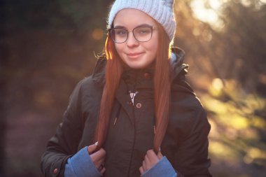 Genç bir çift, modern bir şehrin ortasında yürürken sarılır ve gülümser.