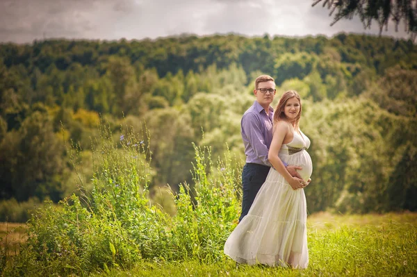 Schöner Mann Und Seine Schöne Schwangere Frau Umarmen Und Lächeln Stockbild