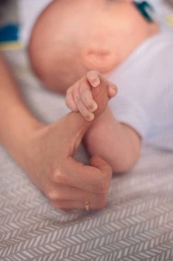 Yeni doğan erkek bebek annesinin kollarında dinleniyor.