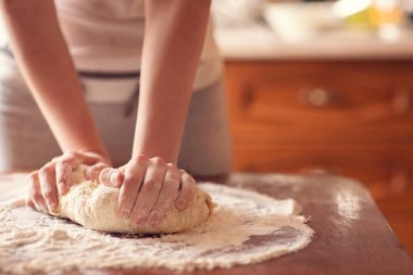 Kadın eli pizza için hamur yapıyor.