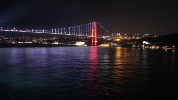 Sailing away from Istanbul 's bridge at night — стоковое видео