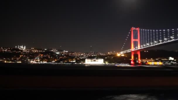 Ночью плавание под Стамбульским мостом — стоковое видео