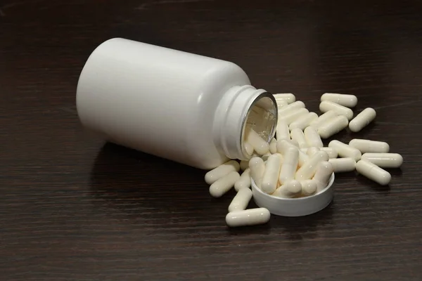 capsules of medicine or vitamins with a jar