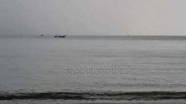 Longtail tekne soldan sağa doğru yüzüyor.