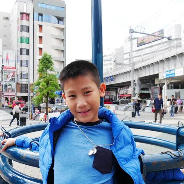 Felice ragazzo asiatico con il piumino blu al centro di Tokyo — Foto Stock