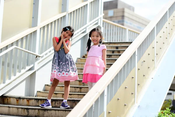 Asian girls standing and walking on stairs outdoors/ Asian baby/ — стокове фото