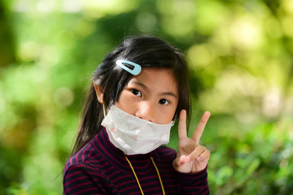 亚洲小女孩获取生病与绿色散景背景室外. — 图库照片