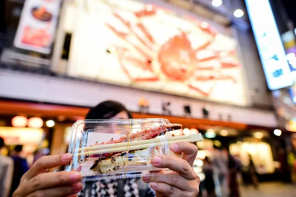 Turista mostrando a la parrilla gran paquete de cangrejo en su mano en Dotonbor — Foto de Stock
