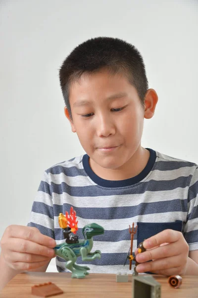 Il ragazzo asiatico sta giocando con il lego. isolato su sfondo grigio — Foto Stock