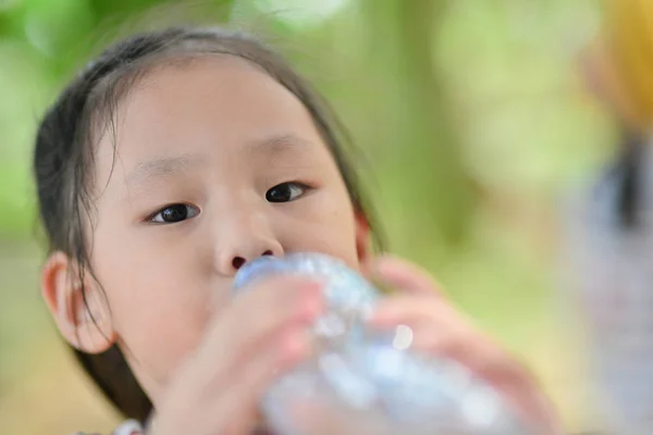 Маленькая девочка пьет минеральную воду — стоковое фото