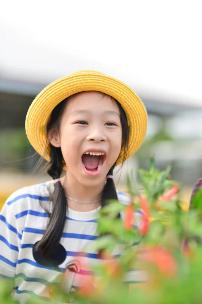 Cute Asian zadumany dziewczyna siedzi z działki warzywne zielonego chili — Zdjęcie stockowe