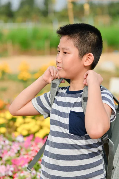 Asian boy with backpack in flower fields — Stock Photo, Image