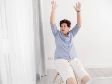 Asya kıdemli kadın dinlenmek evde.