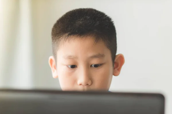 Jovem menino asiático usando a tecnologia laptop em casa . — Fotografia de Stock