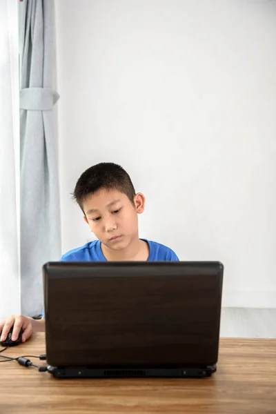 Aziatische jongen met behulp van laptop-technologie thuis. copyspace voor t — Stockfoto