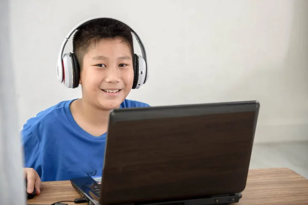 Unga asiatiska pojke med laptop teknik hemma. copyspace för t — Stockfoto
