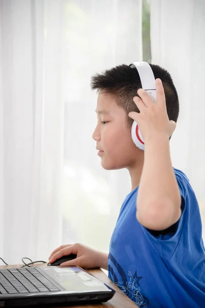 Aziatische jongen met behulp van laptop-technologie thuis. copyspace voor t — Stockfoto