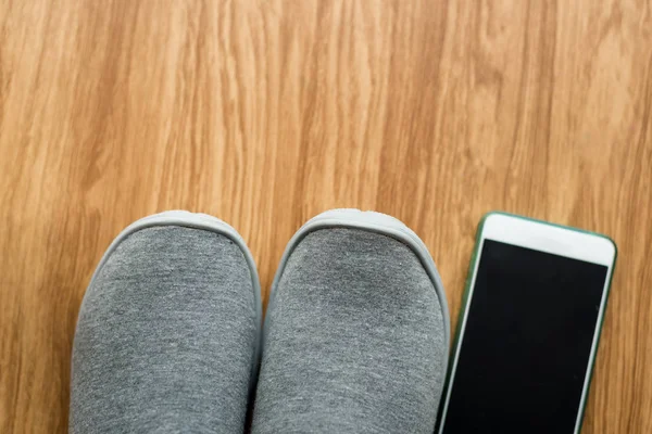 Сіре спортивне взуття на підлозі зі смартфоном вдома. Стиль життя — стокове фото