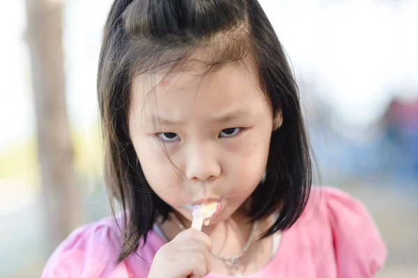 Портрет азиатки, поедающей мороженое — стоковое фото