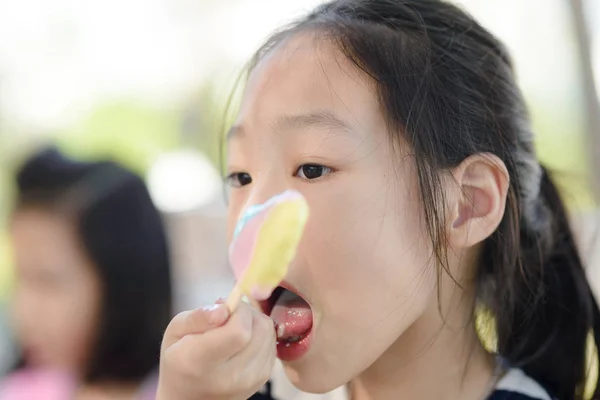 Ritratto di ragazza asiatica che lecca un gelato — Foto Stock