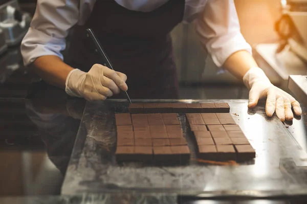 Шеф-повар режет домашний шоколад на кухне . — стоковое фото