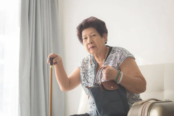 Azjatycka starszy kobieta siedzi w domu i gotowy do podróży — Zdjęcie stockowe