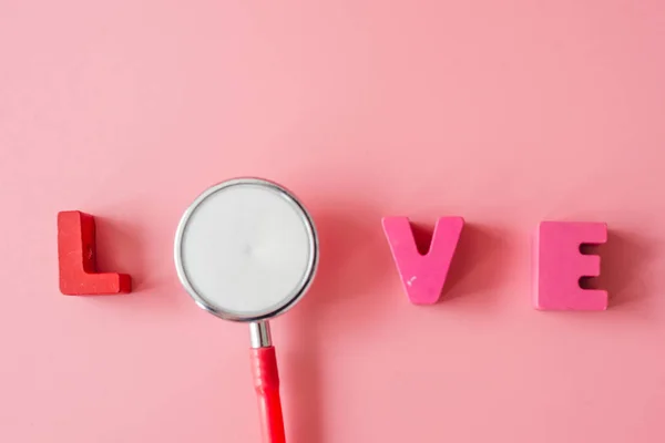 Estetoscópio com amor sobre fundo rosa . — Fotografia de Stock