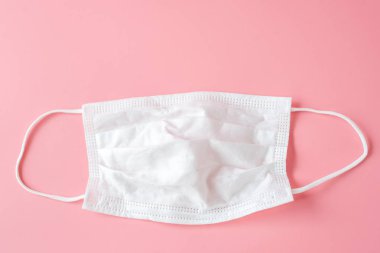 Pembe bir arka plan üzerinde beyaz koruyucu yüz maskesi.
