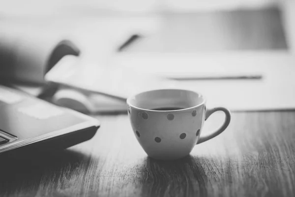 Černá a bílá káva hrnek s notebookem na stole — Stock fotografie
