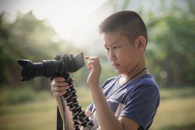 Asyalı çocuk alarak fotoğraf için kamera ile elinde öğrenme 